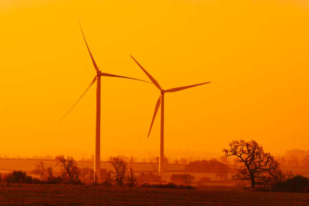 Silhouette of wind turbines at sunriseの写真素材