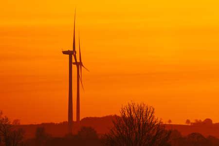 Silhouette of wind turbines at sunriseの写真素材