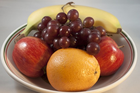 A bowl of beautiful fresh fruit, including bananas, apples grapes and oranges.の写真素材