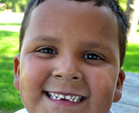 Smiling hispanic boy with missing bottom teeth.の写真素材