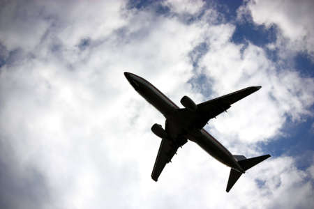 Silhouette of aircraft flying with cloudscape background.の写真素材