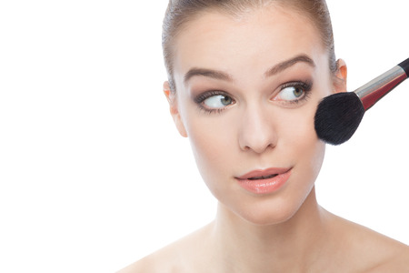 Woman applying make-up  with a brushの写真素材