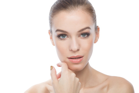 Young woman touching her face isolated on a white backgroundの写真素材