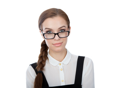 A studio portrait of a beautiful young woman wearing glasses with a smart expression.Looking at the camera.Isolated on white. Copy space available.の写真素材