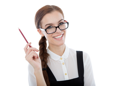 A studio portrait of a beautiful young woman wearing glasses, holding a pencil and having a great ideea. Isolated on white. Copy space available.の写真素材