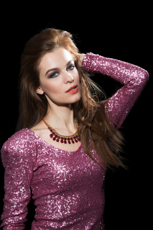 Portrait of a beautiful young woman in a pink party dress. Isolated on black background.の写真素材