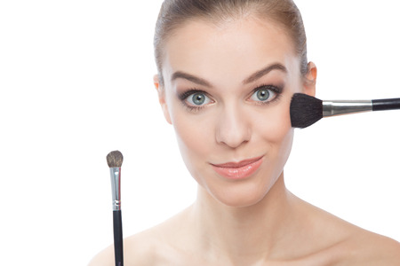 Young beautiful woman making make-up with brushesの写真素材