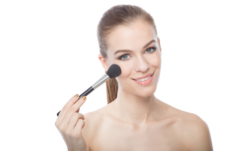 Woman applying blush with a blush brushの写真素材