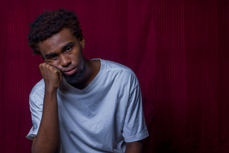 Sad black man in studio photoの写真素材