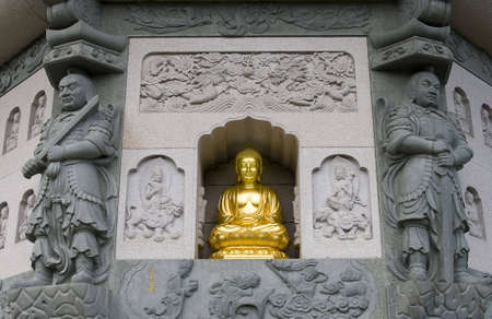 A golden buddha incet in the wall of a pagodaの写真素材