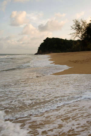 Strolling up the beach as the waves wash up.