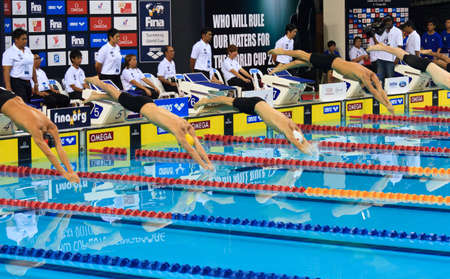 Competitors of the 200m butterfly event about to shatter their reflections. Lane 3: Alexandre Liess (SUI), lane 4: Travis Nederpelt (AUS), lane 5: Brian Johns (CAN), Lane 6: Thiago Pereira (BRA), Lane 7: Shane Asbury (AUS). Singapore. 16/10/2010.のeditorial素材