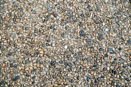 A close up of sidewalk made of irregular pebbles set in concreteの写真素材