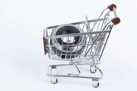 Side view of a wire frame shopping cart with brown trim holding electronic parts isolated on a white backgroundの写真素材