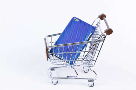 Side view of a wire frame shopping cart with brown trim holding electronic parts isolated on a white...