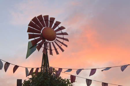 A country style weather vane catches the breeze as the sun sets.