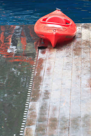 A red ocean kayak sits ready for action on an icy dockの写真素材