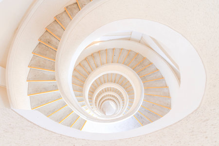 A spiral staircase that opens up to an almond shape at the topの写真素材