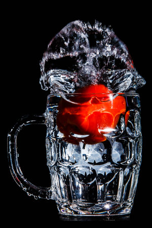 Artistic splash of a tomato created after being dropped into a clear goblet.の写真素材