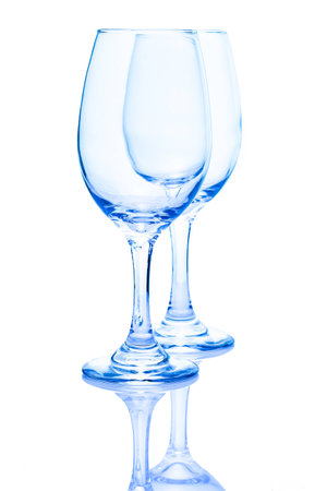 A pair of light blue wine glasses isolated on white with a reflectionの写真素材