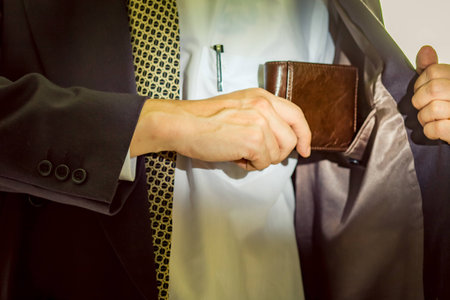 A business man taking out his wallet from suit pocket.の写真素材