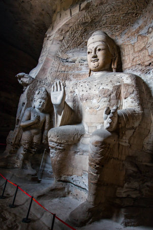 Giant stone Buddha scultpures in one of the main caves at the Yungang Grottos.の写真素材
