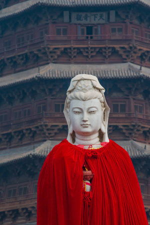 A red robe placed around the Buddha Sakyamuni statue in front of the Wooden Pagoda.の写真素材