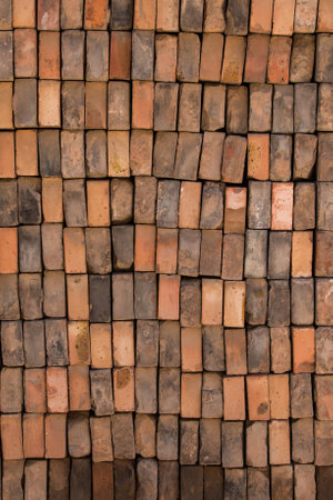 Close up of a wall made up of vertically stacked bricks