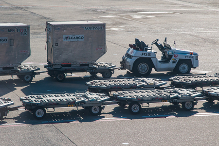 Japan Airlines cargo trolley on standby loaded with containersのeditorial素材