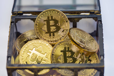 A treasure chest full of golden bitcoins on a clean background