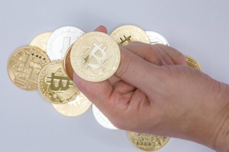 Close up of a hand about to flip a Bitcoin coinの写真素材