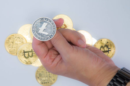 Close up of a hand about to flip a Litecoin coinの写真素材