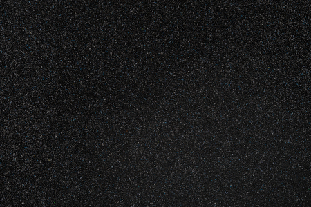 Coal black colored sand paper textured background with sparkles and glittersの写真素材