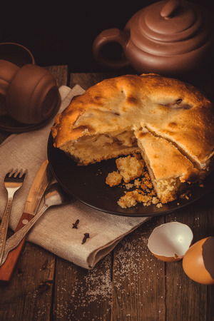 Piece of pie and pottery for tea on an old wooden table. It is toned, processing in style a vintage. Close up, small depth of sharpnessの写真素材