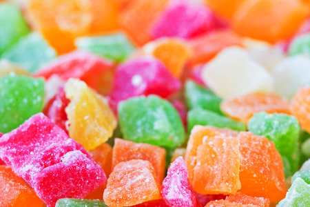 The candied pieces of dried fruit close up. Multi-colored appetizing candied fruits, selective focus