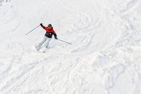 PYRENEES, ANDORRA - FEBRUARY 6, 2018: Downhill skier moves down from a steep slope. It is a lot of friable snow, freerideのeditorial素材