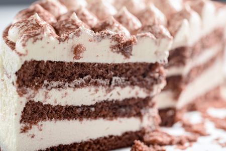 Cut cake close up. Chocolate sponge cake and light cream. Selective focusの写真素材