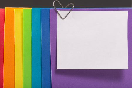 A rainbow colored note paper with a heart clip