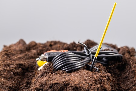 The RCA jack cable is buried in the ground like a grave.の写真素材