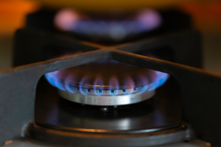 Blue flame of a burning gas stove burner. Close-up, selective soft focus