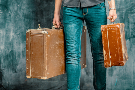 A man carries two old plywood cases with scratchesの写真素材