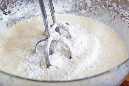 The mixer nozzle is immersed in a pie doughの写真素材