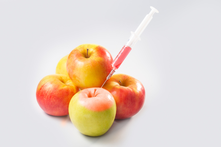 Syringe in green apple with red paint.の写真素材