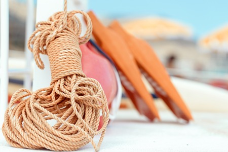 The equipment of the rescue station on the beach - a rope against the background of buoys and a lifebuoyの写真素材