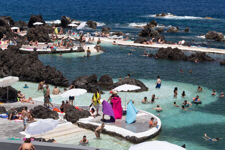 Porto Moniz, Madeira, Portugal - July 25, 2018: Vacationers sunbathe and swim in lava poolsのeditorial素材