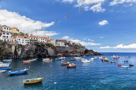 Camara de Lobos, Madeira, Portugal - July 26, 2018: Bright boats of fishermen in the bay of the villageのeditorial素材