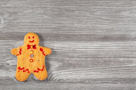 Traditional little man shaped christmas cookie on gray wooden table.の写真素材