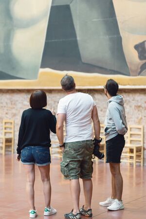 FIGUERES, SPAIN - AUGUST 4, 2019: Visitors to the Salvador Dali Museum in Figueiros, Spain, face one of his paintingsのeditorial素材