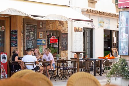 TOSSA DE MAR,SPAIN - AUGUST 1, 2019: A group of tourists at the table of a street cafe in Spain.のeditorial素材