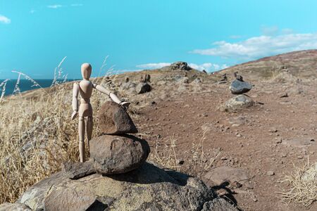 The wooden man Gestalt stopped to rest at the rocks on the tourist trail in Madeira.の写真素材